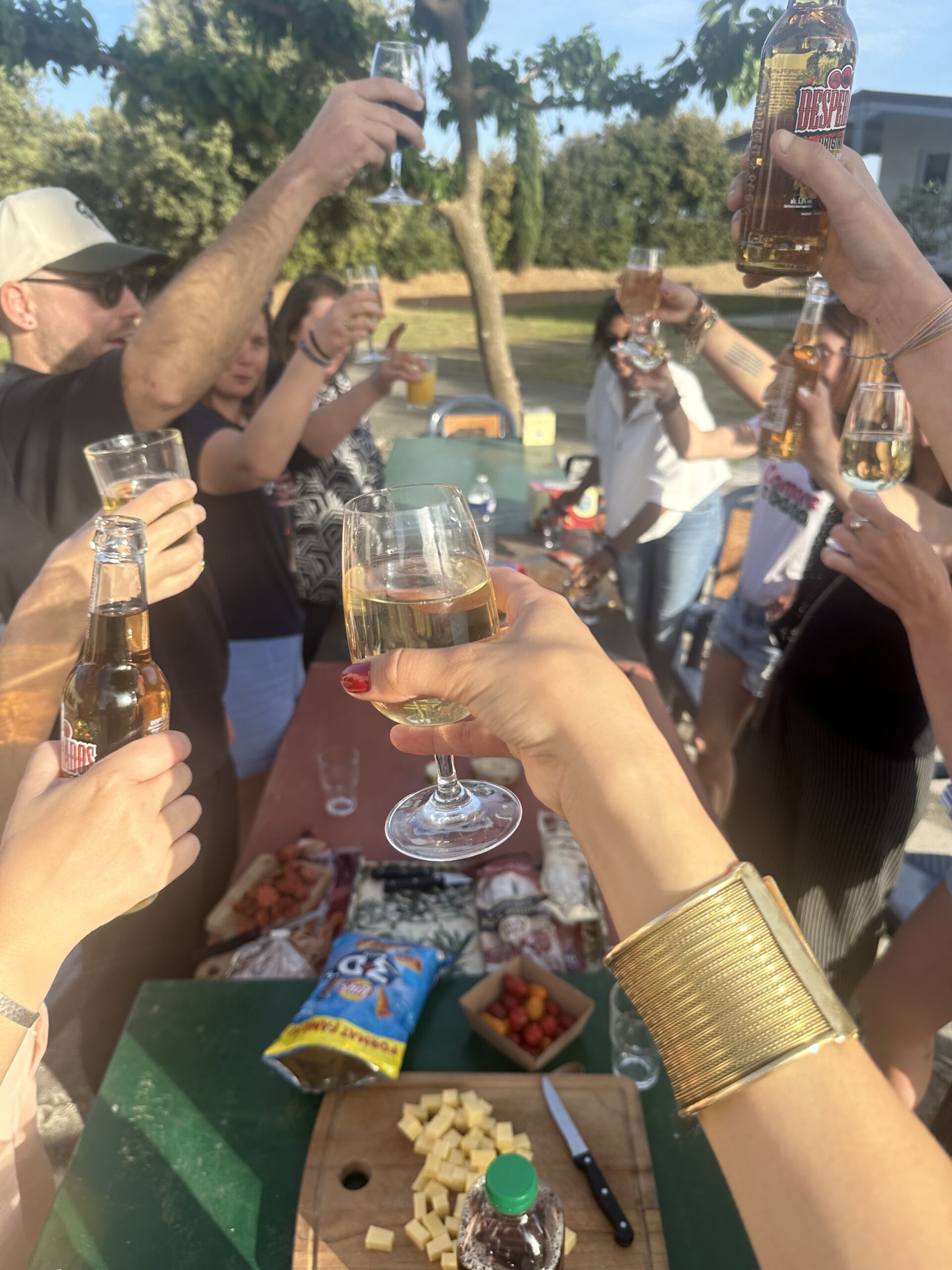 people holding clear glass bottles during daytime